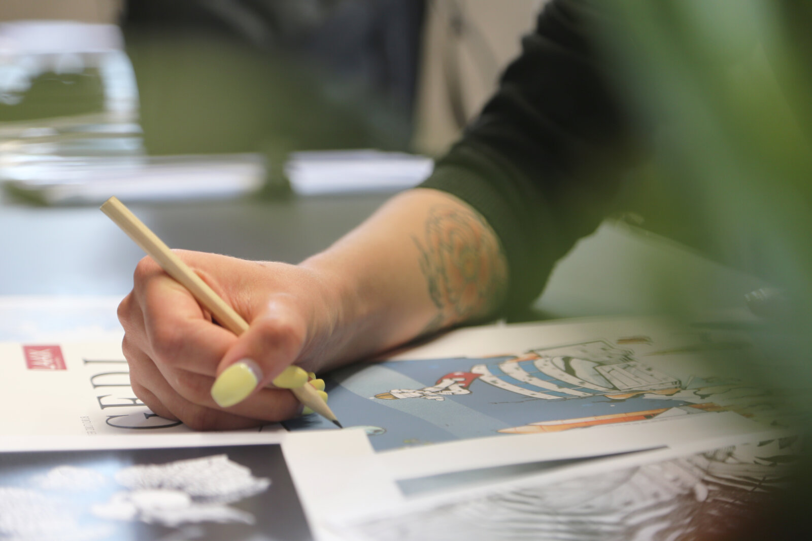 Hand einer Person, welche auf ein Blatt Papier zeichnet.