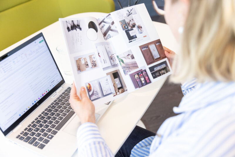 Sichtung von Design- und Corporate-Identity-Beispielen im Büro. Symbolbild für Branding, Grafikdesign, Markenentwicklung, visuelle Kommunikation und Kreativprozesse.