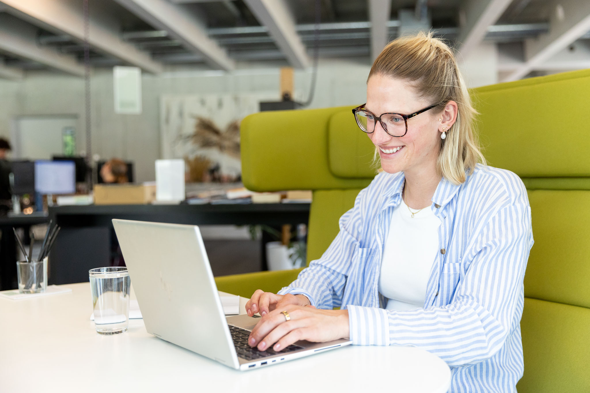 Mitarbeiterin mit Laptop im modernen Büro. Symbolbild für Marketing, Kommunikation, Projektmanagement, digitale Arbeitsprozesse und flexible Arbeitswelten.